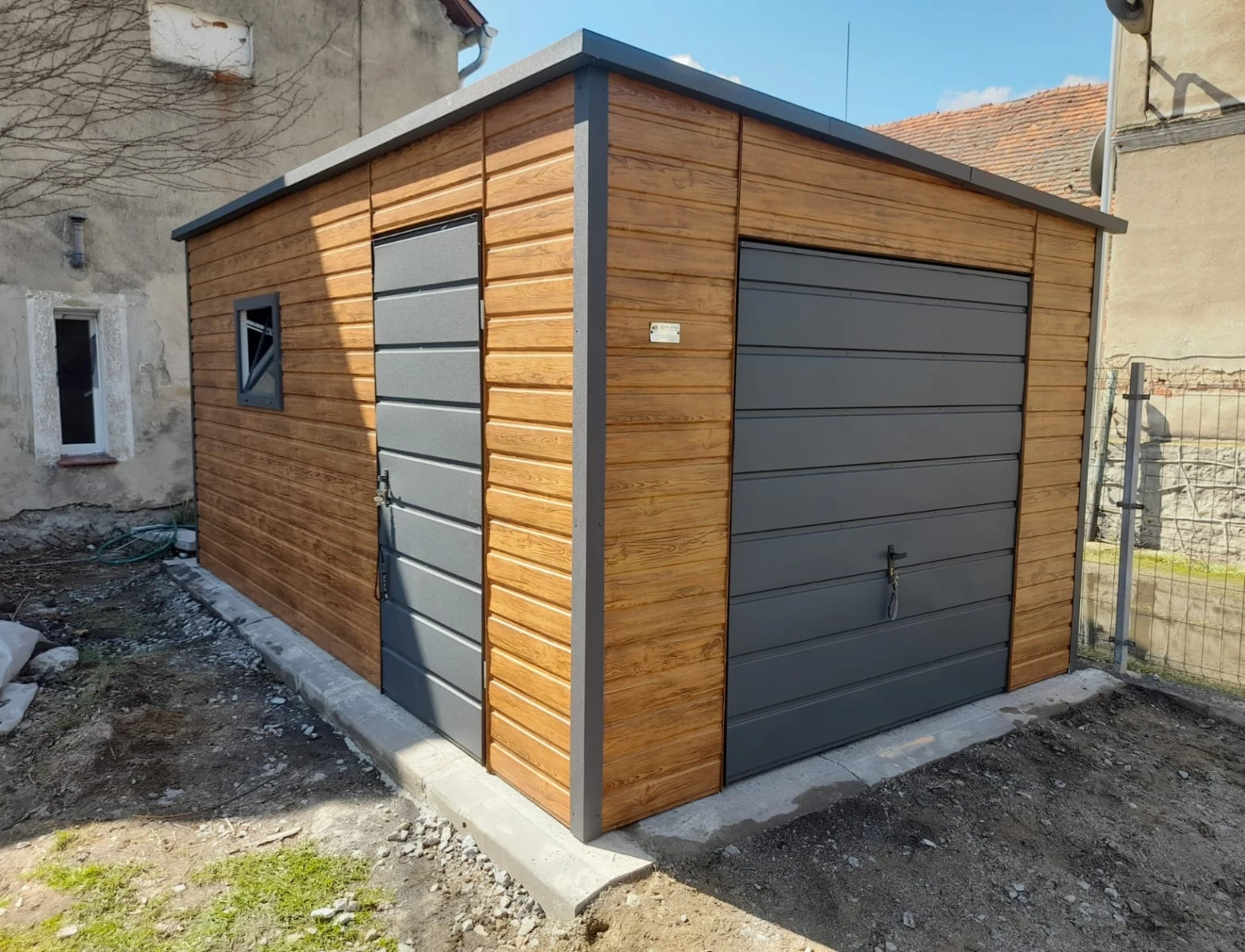 Garaże blaszane – nowoczesny, wolnostojący garaż z drewnopodobnymi panelami, bocznym wejściem i oknem